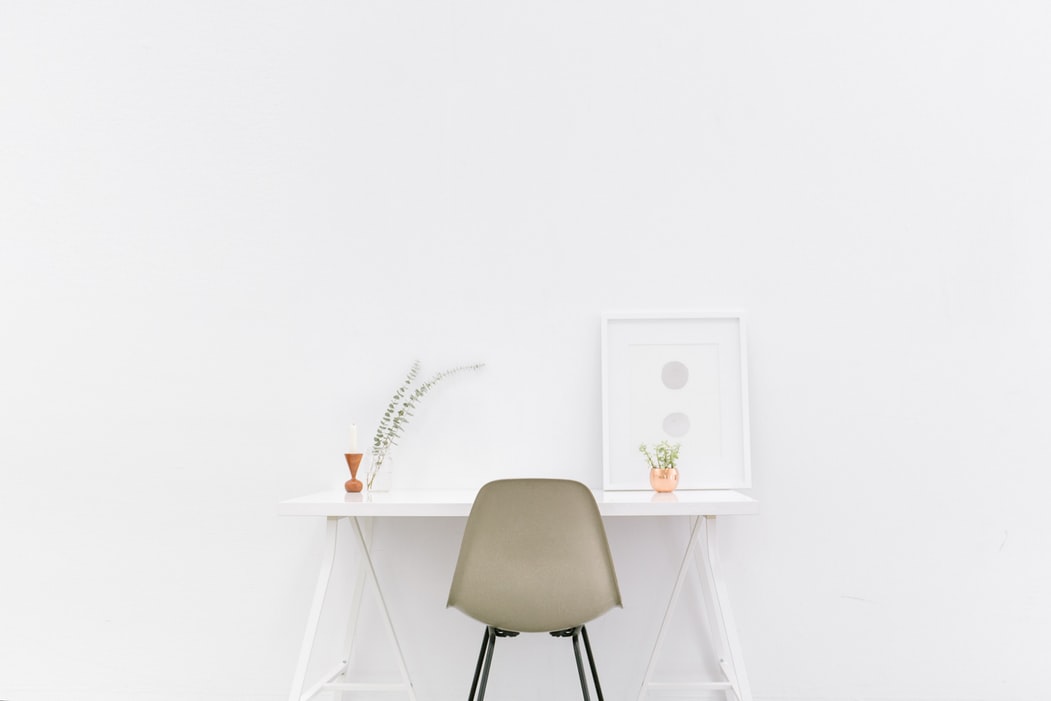 a chair white chair at a white desk on a white wall